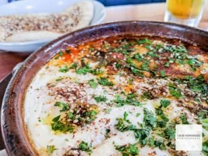 Shakshuka: chickpea, peppers & tomato stew, griddled halloumi, baked eggs with pita